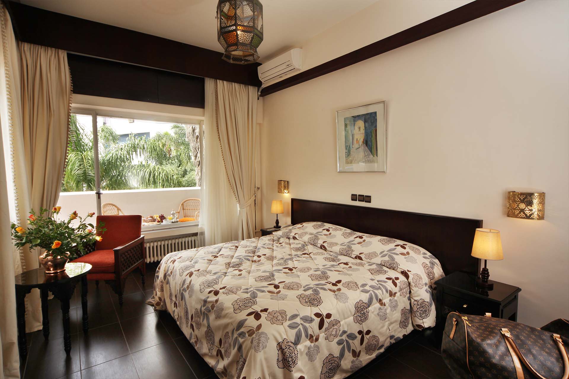 Habitación con cama doble y balcón con vistas a la vegetación