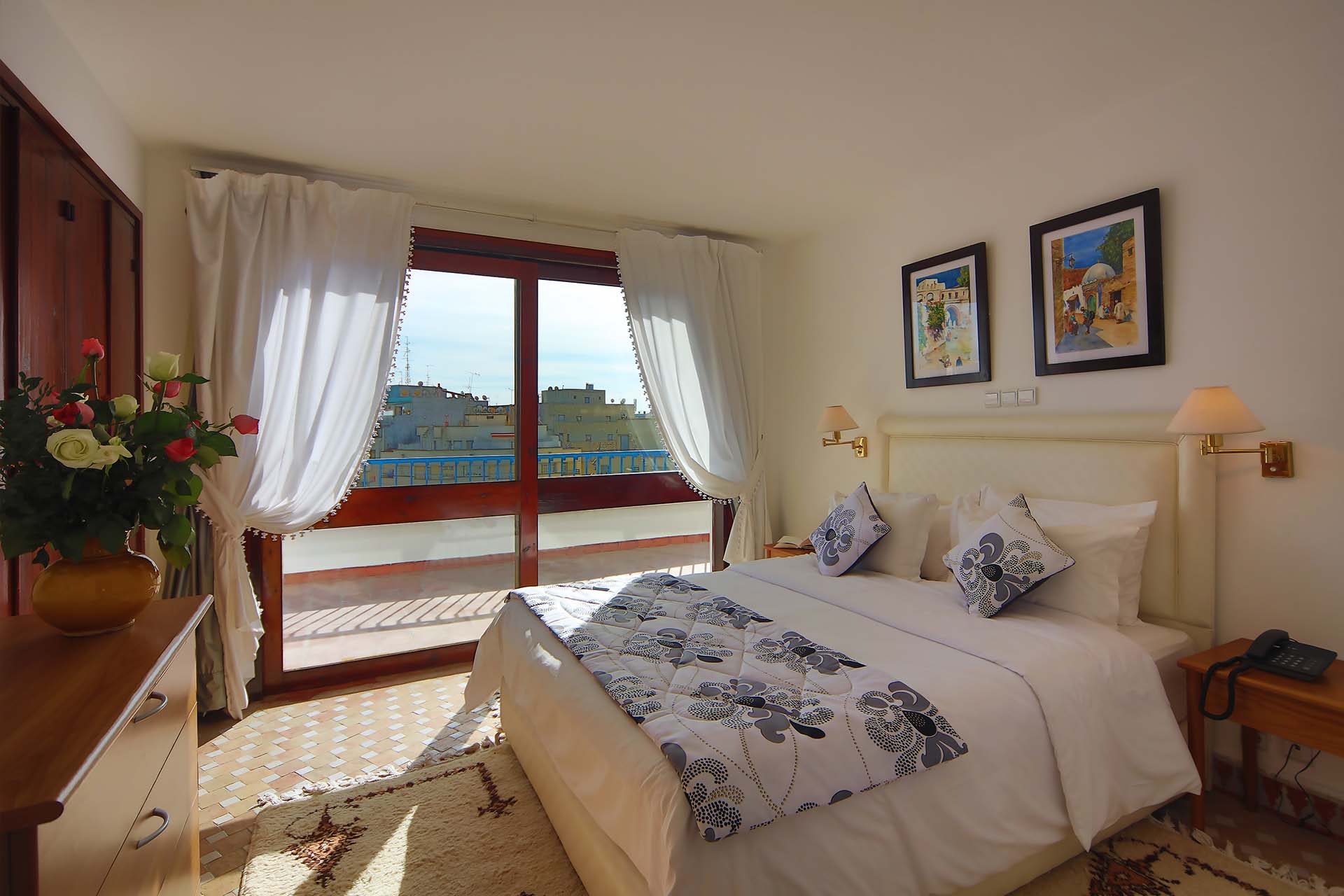 Habitación con cama doble y balcón con vistas a la ciudad