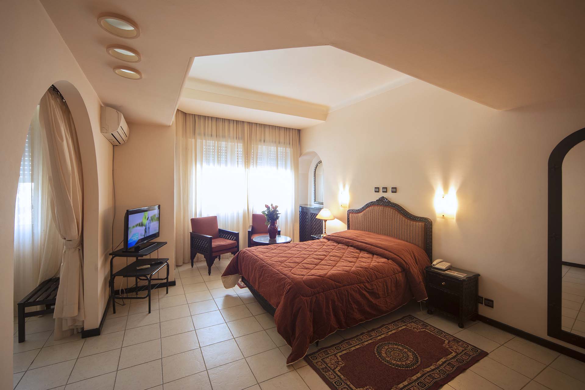 Habitación con cama doble, televisión y sillones