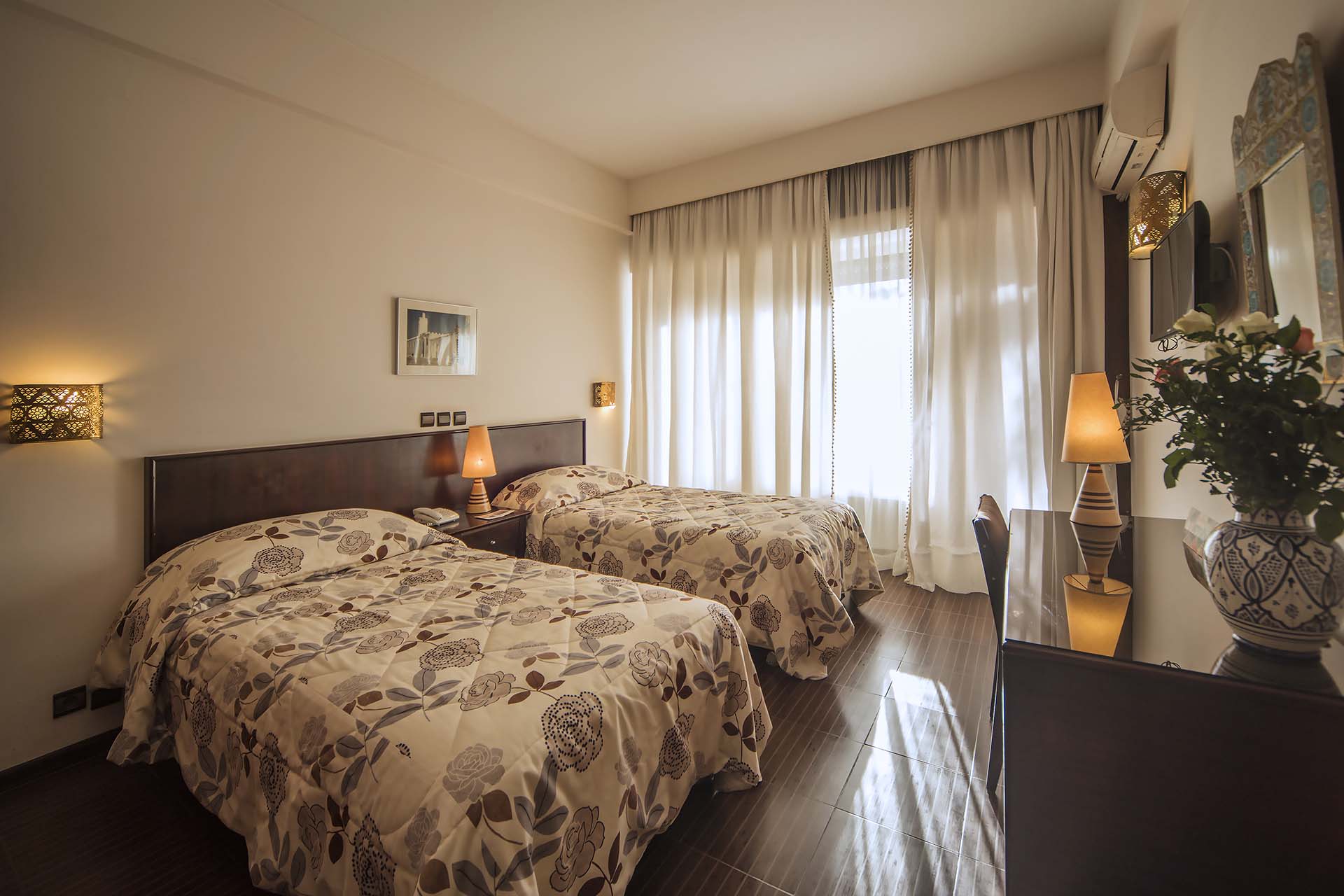 Habitación con dos camas y ventana orientada al balcón