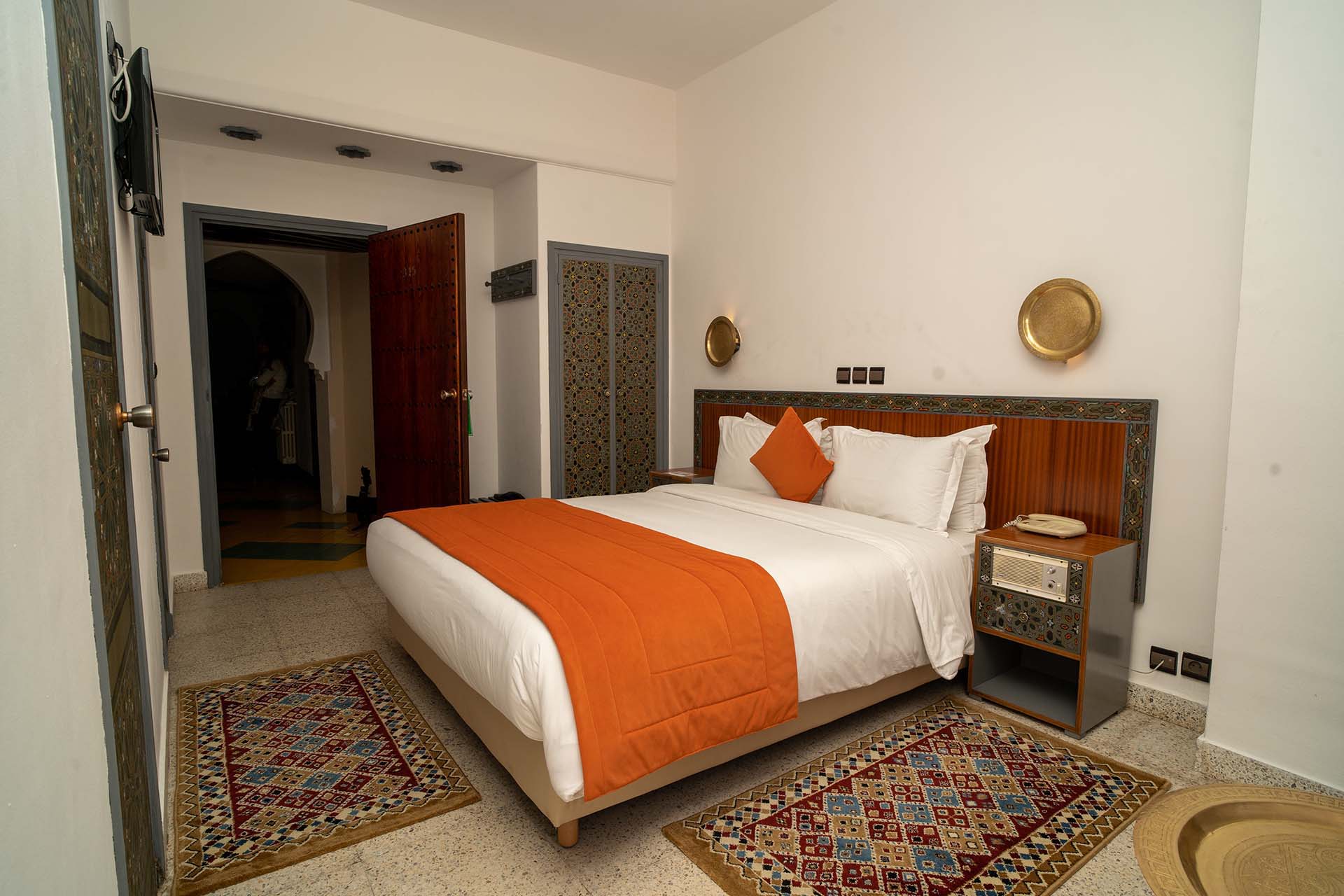 Habitación con cama doble y camino de cama naranja