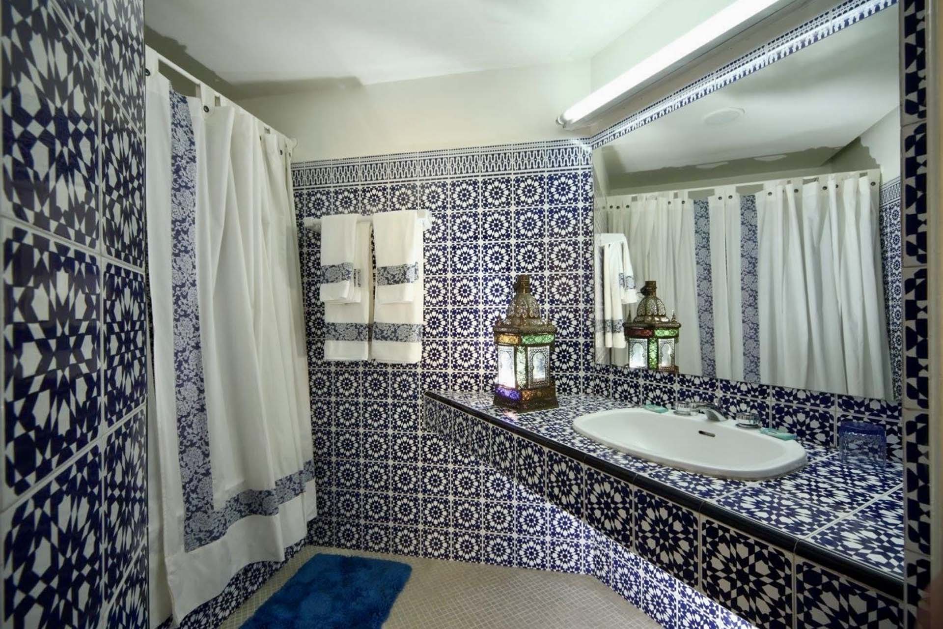 Baño con azulejos estampados azules y blancos