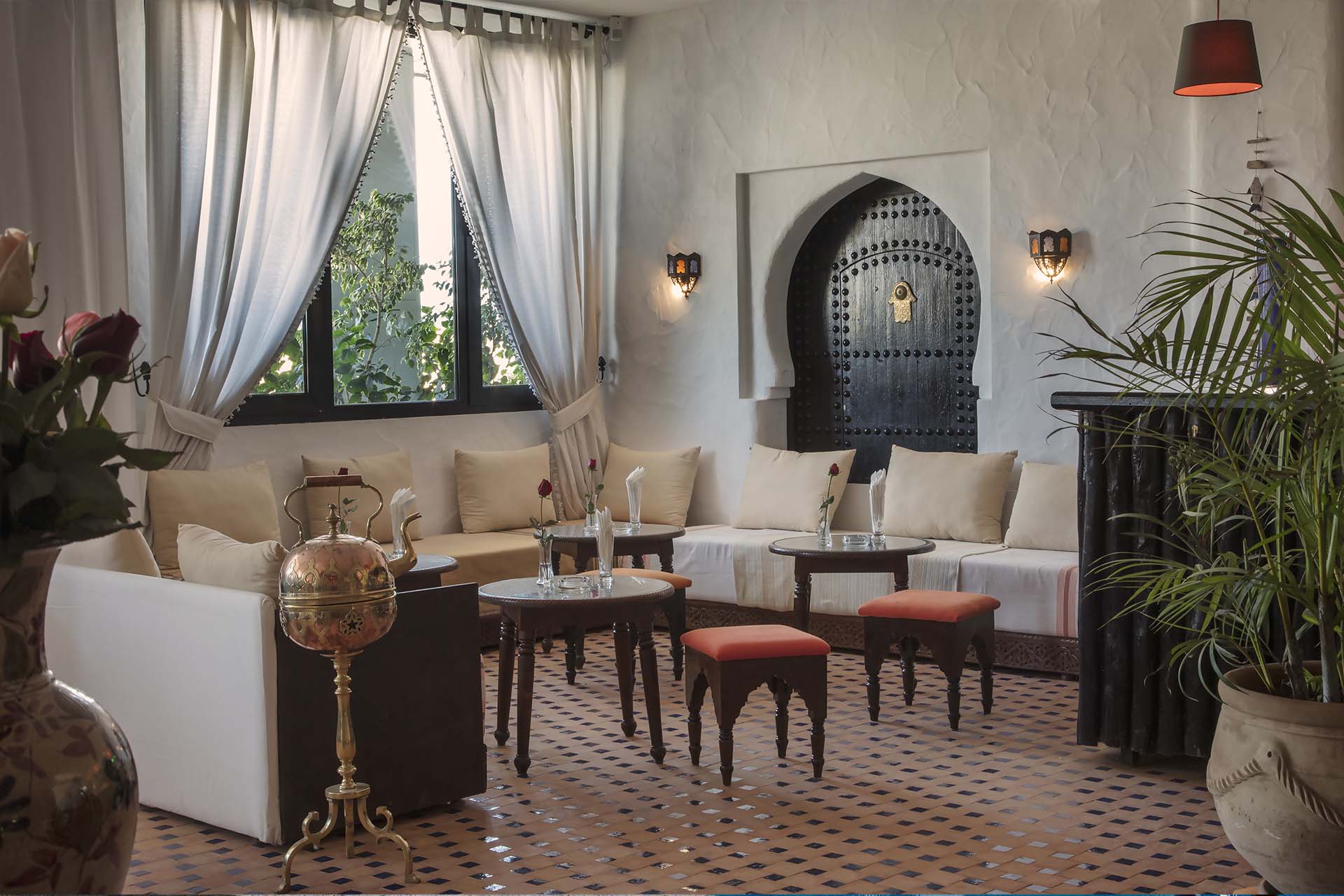 Salón de estilo marroquí con sofás y mesas de té en el hotel Chellah